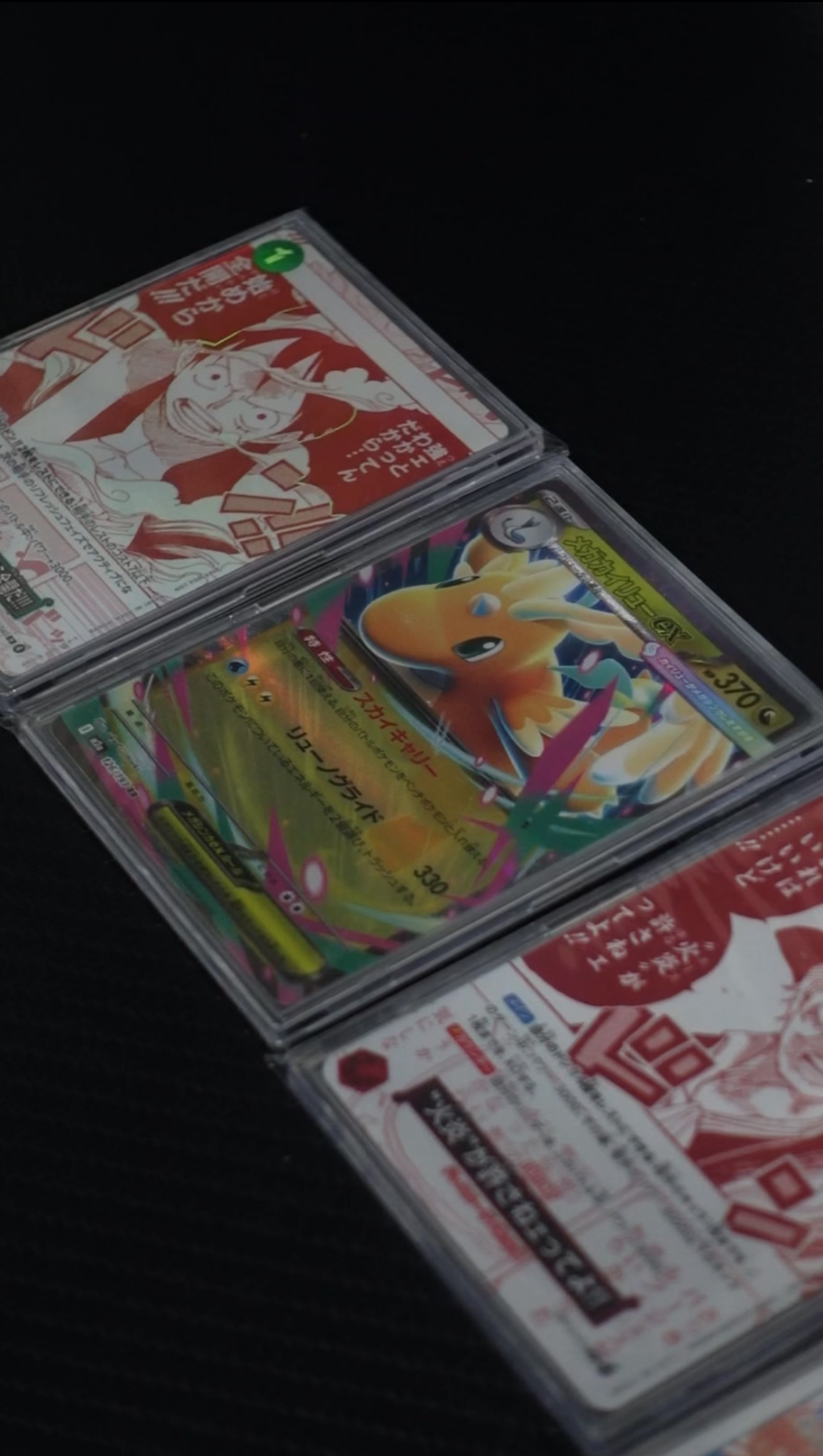 One Japanese Pokémon cards and Two Japanese One Piece cards in RSL.lab slabs laid out together